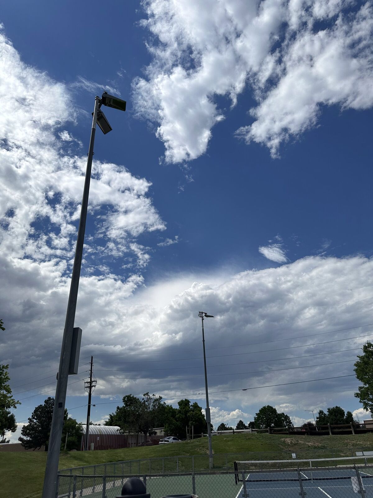 RMES crew installing an LED sports lighting fixture on a stadium pole